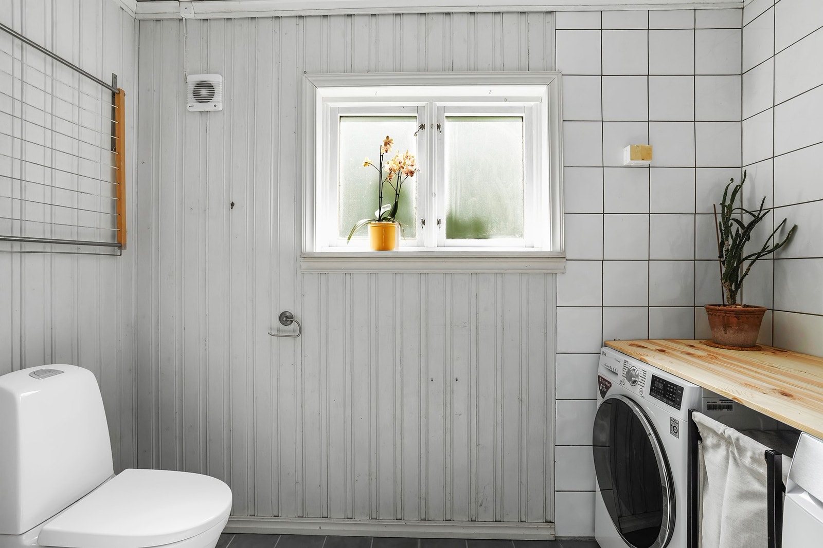 Badet har flislagt gulv og gulvvarme. Veggene er utført med en kombinasjon av fliser og panel, mens himlingen har panelbord Galleribilde