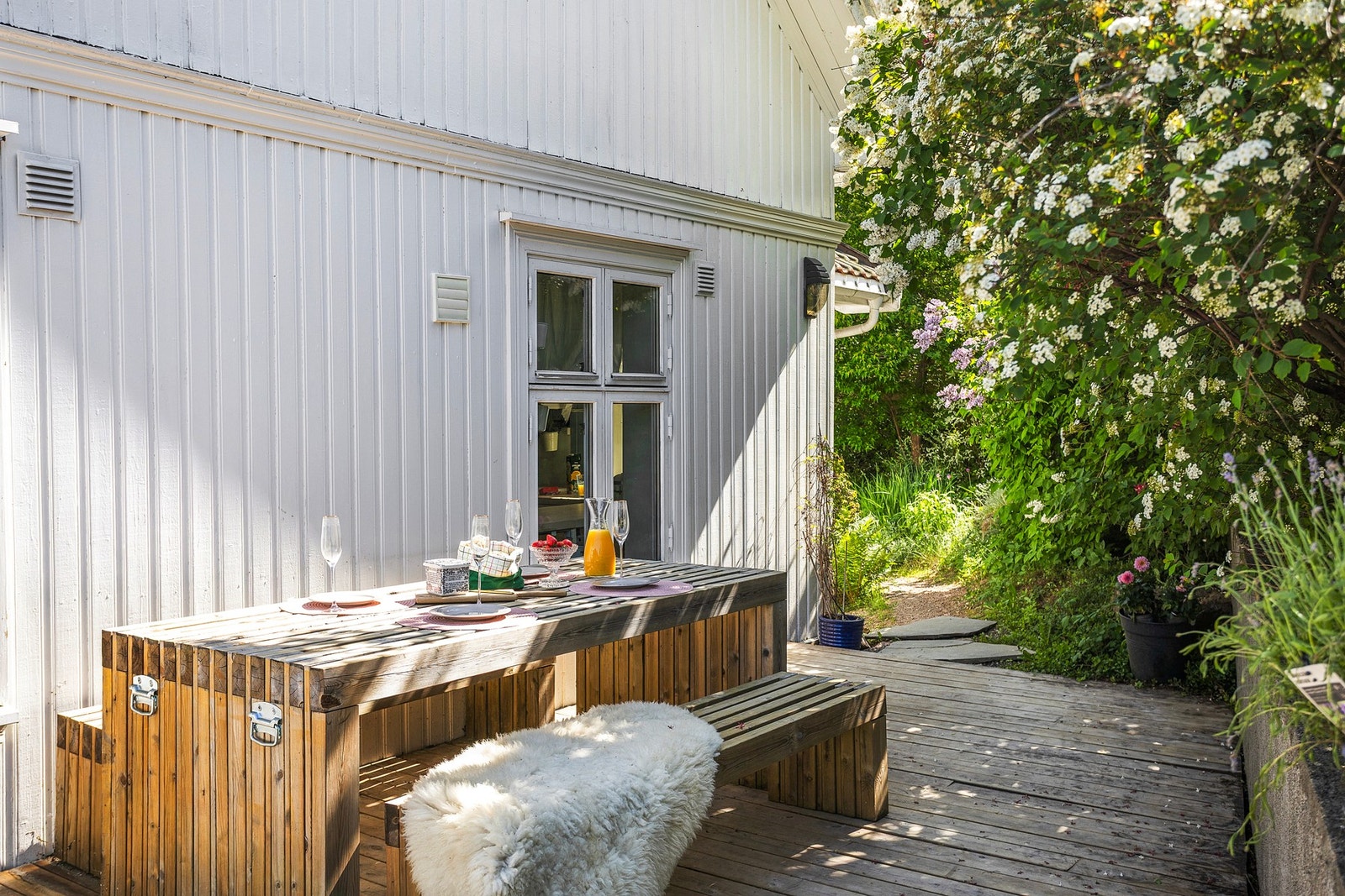 Terrasseplattingen strekker seg på to sider av boligen Galleribilde