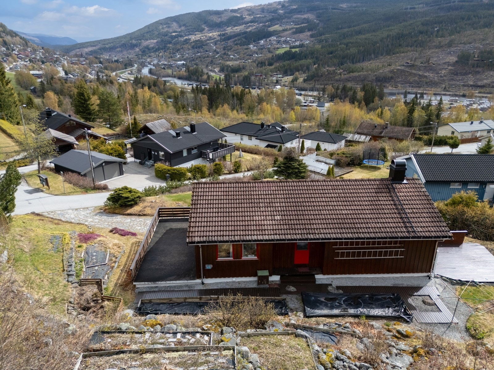 Huset ligger på en skrånende tomt med opparbeidet hage og gårdsrom. Galleribilde