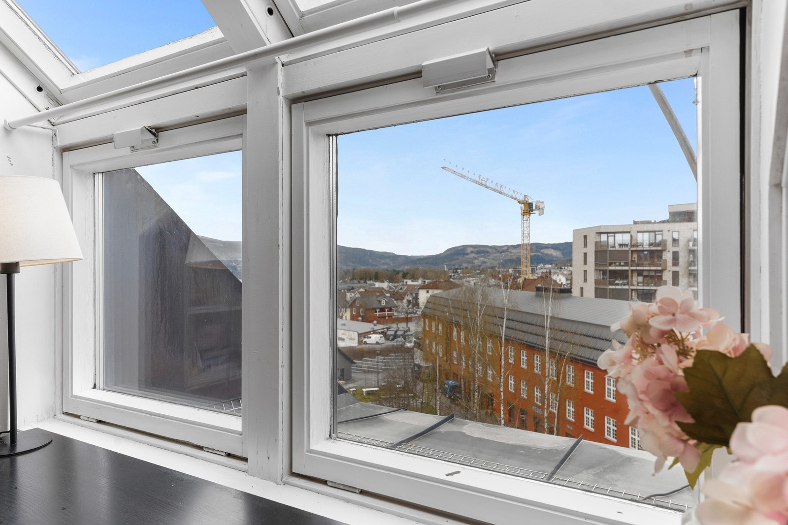 Flott utsikt fra soverommet gjennom store vindusflater som gir godt lysinnslipp og utsyn over bymiljøet og omkringliggende landskap. Galleribilde