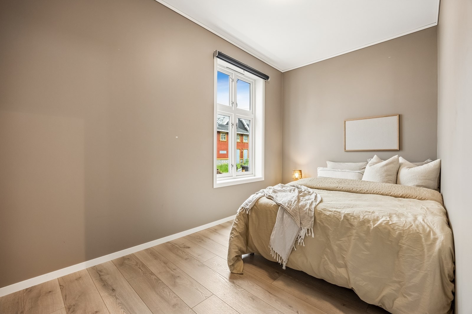 Soverom med malte flater og laminat på gulv, i tråd med resten av boligens materialvalg. Soverom 2 i første etasje. Galleribilde