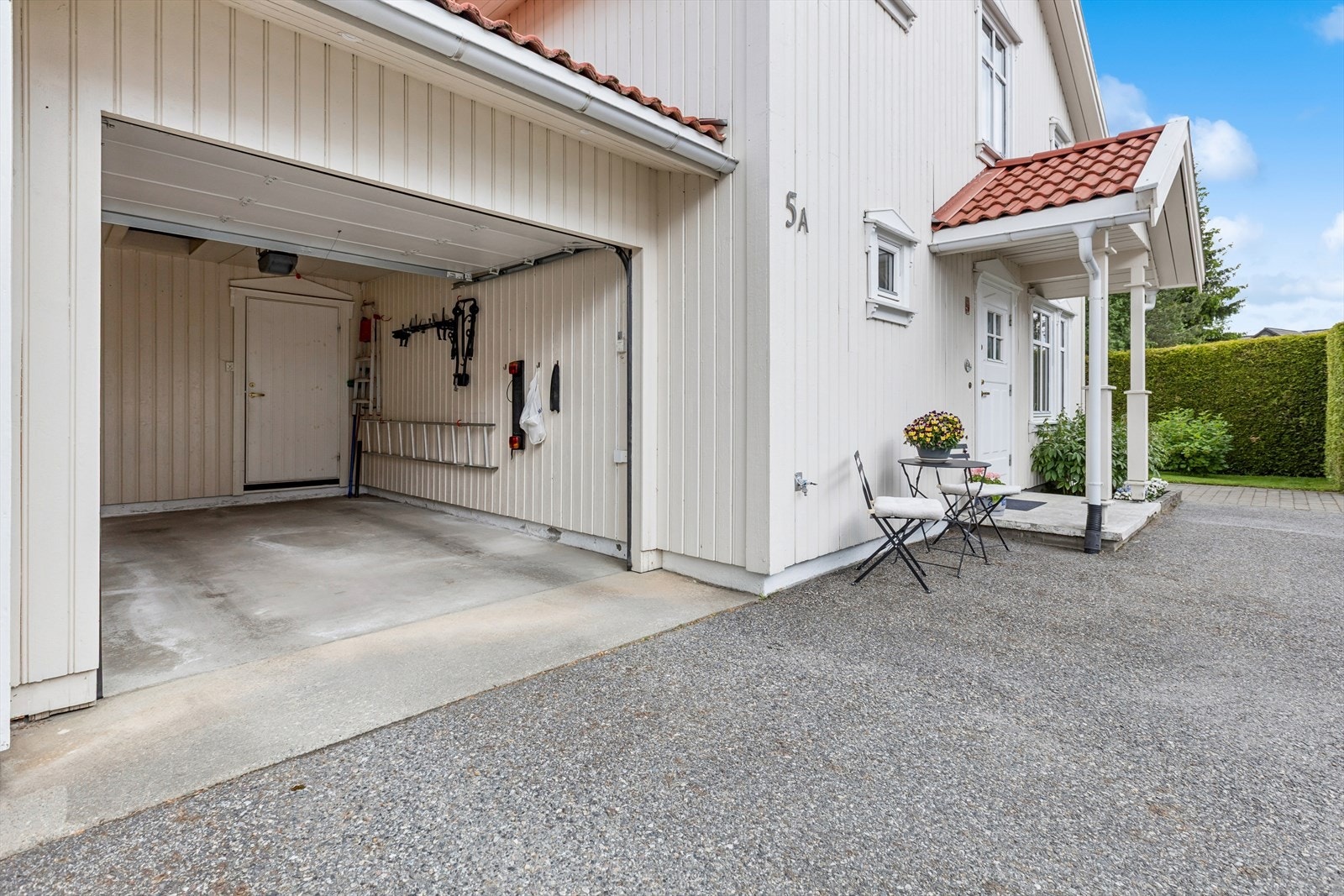 Garasje med elektrisk portåpner og en bakenforliggende sportsbod for ekstra lagring. Galleribilde