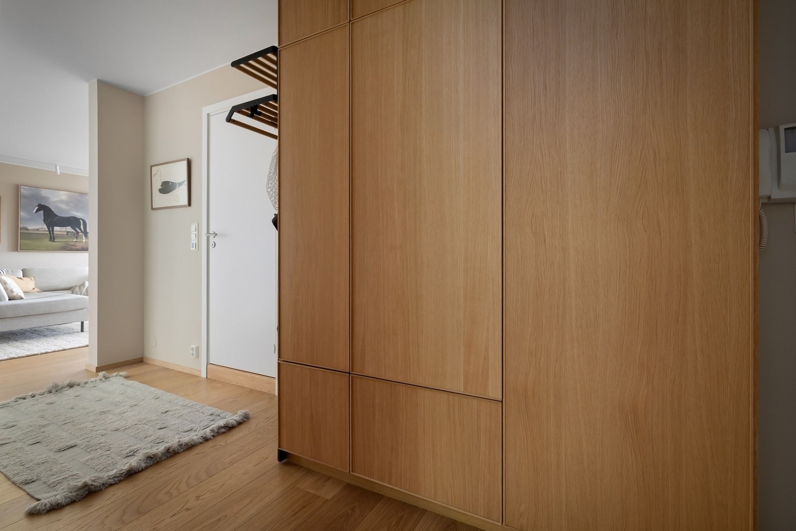 God plass til jakker og sko i plassbygd garderobe med skapdører i eik levert av Ikea Galleribilde