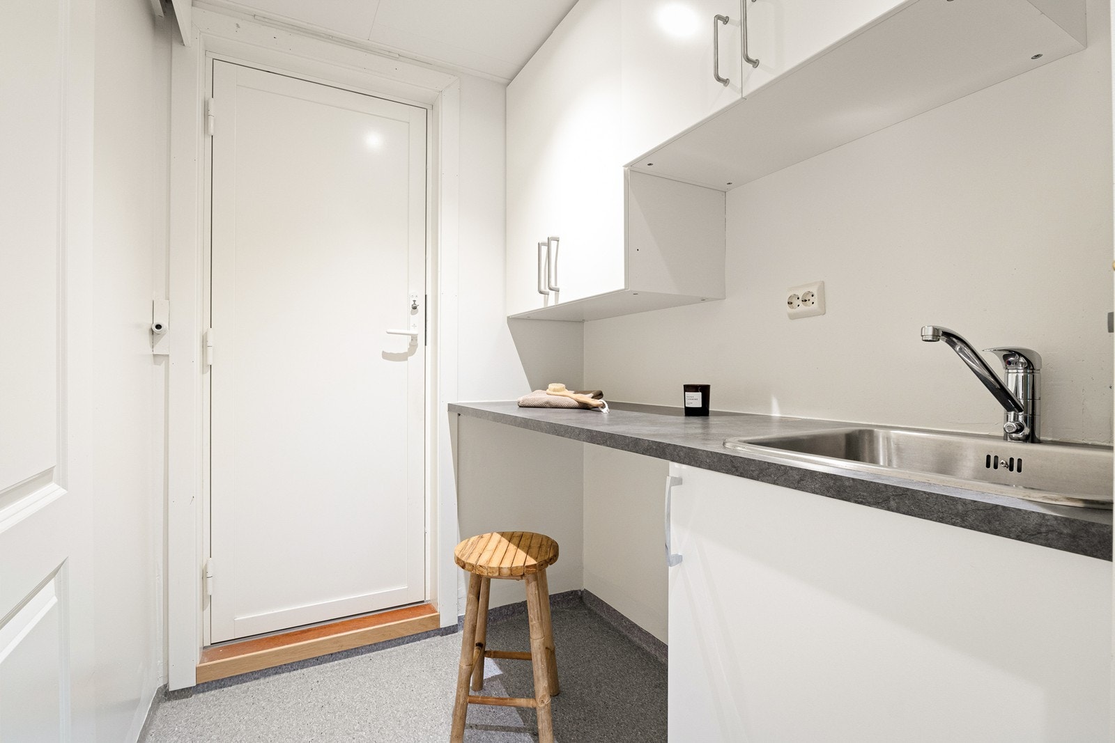 Praktisk vaskerom med benkeskap og nedfelt stålvask, samt opplegg og god plass til både vaskemaskin og tørketrommel. Rommet har direkte utgang til tørkerom/bod på balkongen, noe som gir en funksjonell løsning i hverdagen. Galleribilde