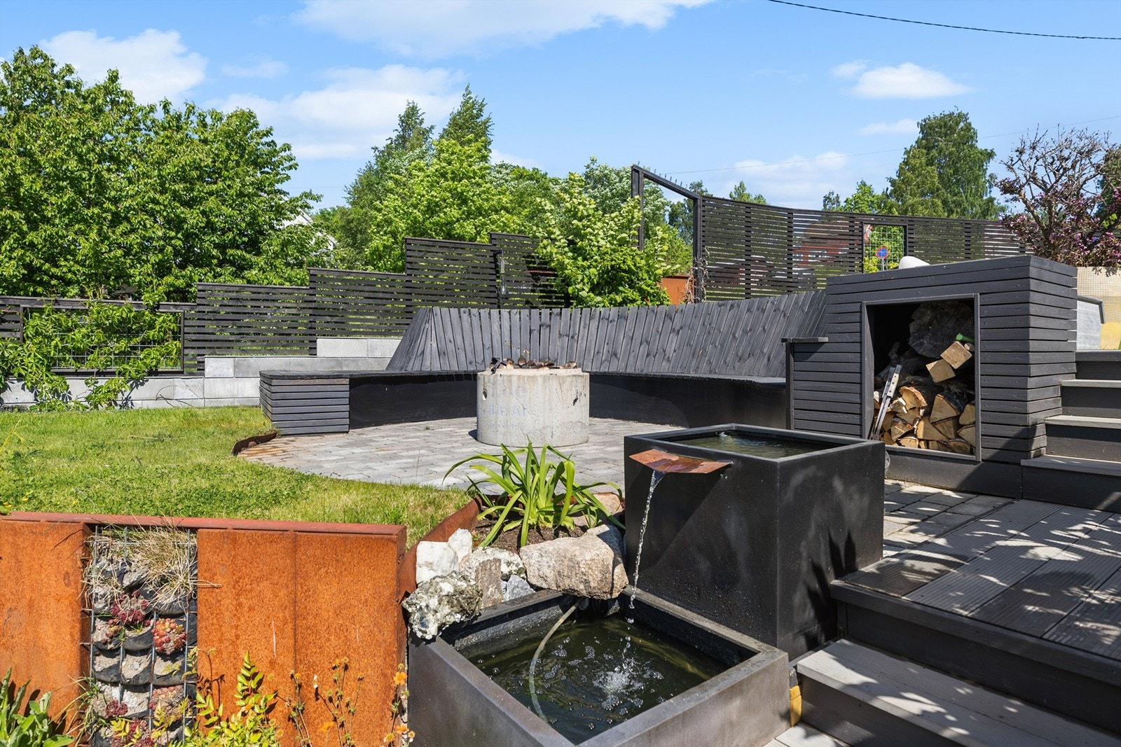 Sommerdagene kan nytes fra morgen til kveld, omgitt av vakre beplantninger, steinbed og stemningsfulle detaljer. Det flotte vannfallet tilfører hagen et eksklusivt preg og skaper en harmonisk atmosfære. Galleribilde