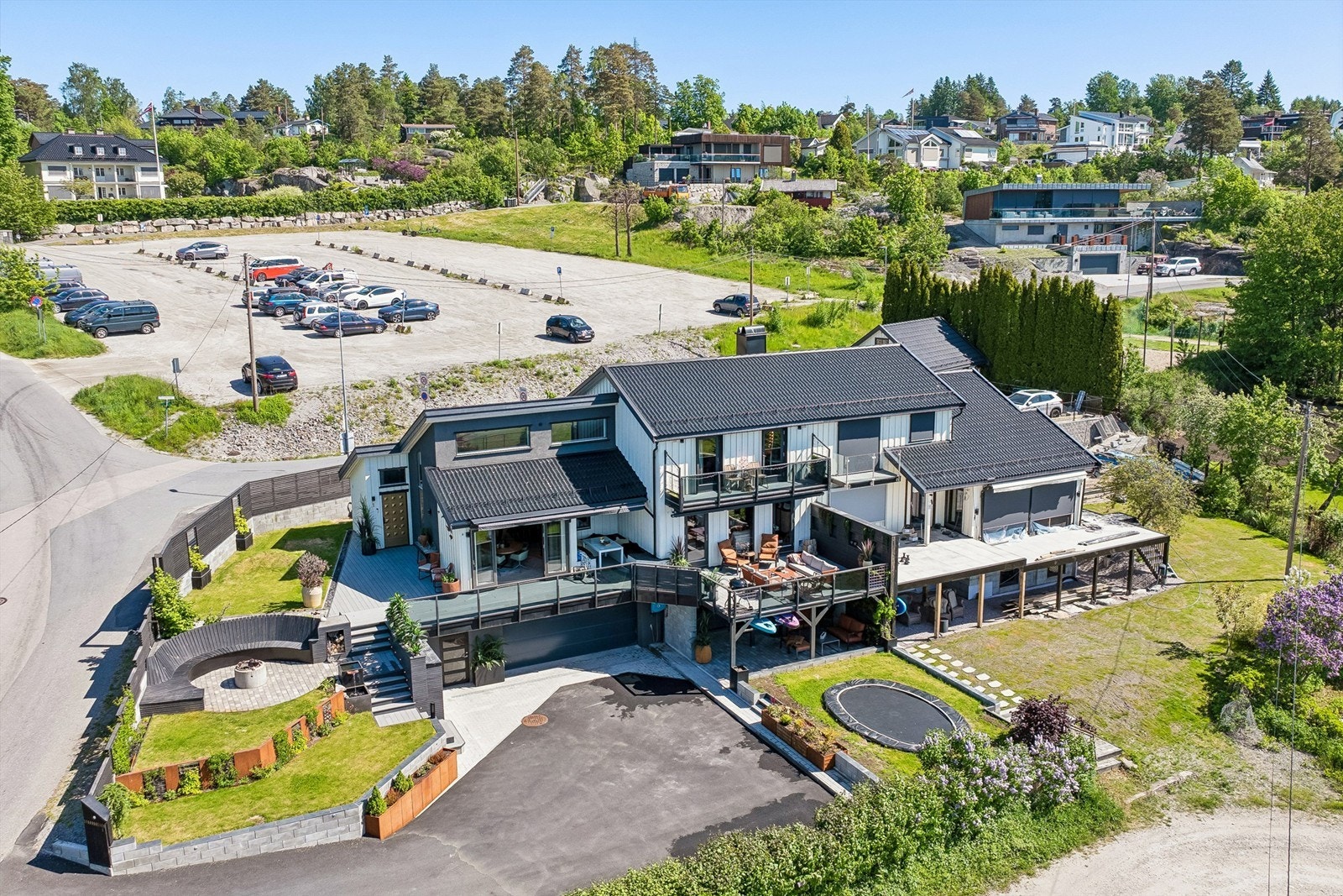 En velstelt plen gir rikelig med plass til lek, aktivitet og familiekos og den nedgravde trampolinen er en favoritt blant de yngste og passer perfekt inn i hagens helhetlige uttrykk. Galleribilde