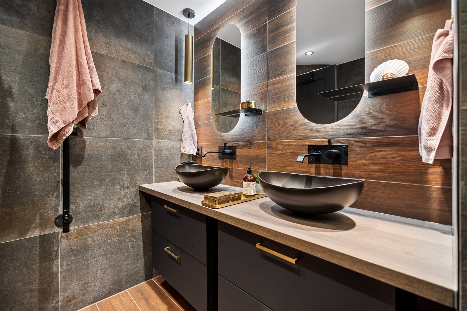 Badet er eksklusivt med gjennomførte detaljer! Stilren dobbel servantinnredning med lekre bolleservanter, veggmonterte kraner, speil med elegant sidelys og takhengte lamper skaper et moderne og sofistikert uttrykk. Galleribilde