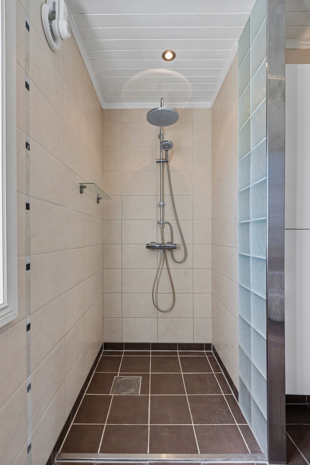 I tillegg til badekar har badet et separat dusjhjørne. Rommet har elektrisk styrt vifte. Galleribilde