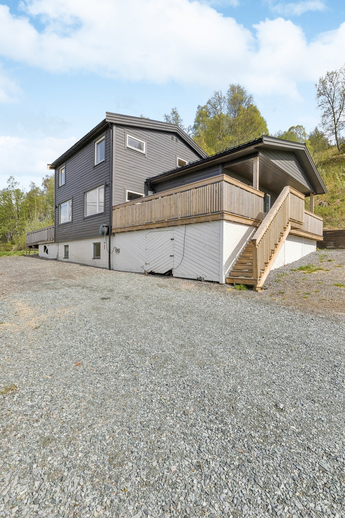 Tomten er opparbeidet med et gruset parkeringsareal. Utvendig trapp i impregnert trevirke. Galleribilde