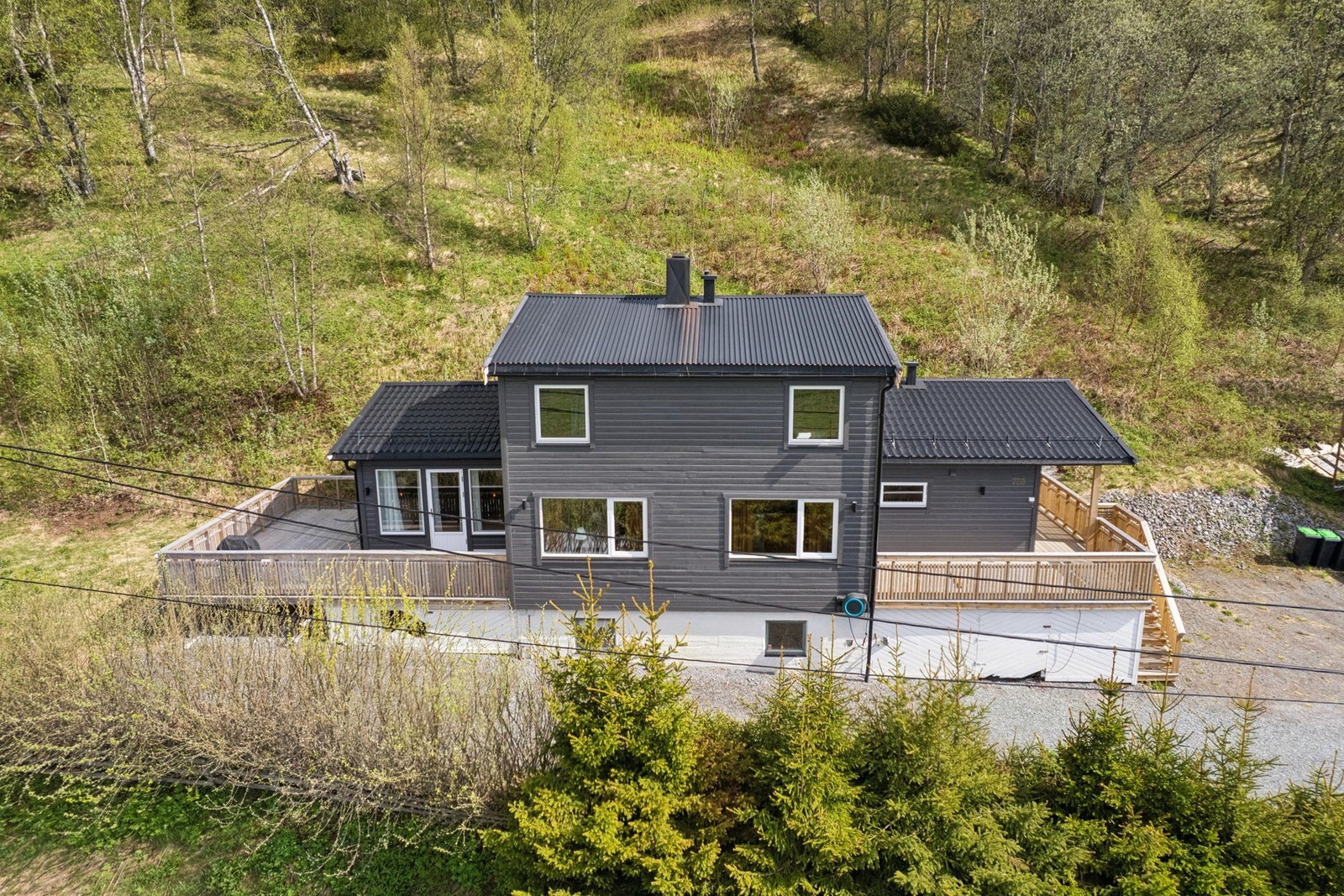 Eiendommen ligger i landlige omgivelser med lett hellende terreng som er opparbeidet med parkeringsareal og plen. Galleribilde