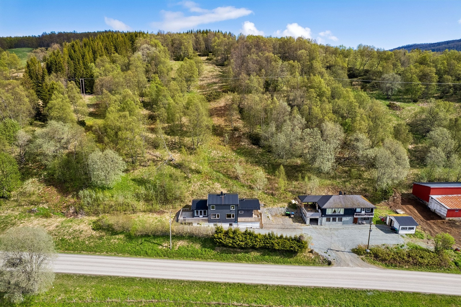 Boligen ligger tilbaketrukket fra veien i et lett hellende terreng. Galleribilde