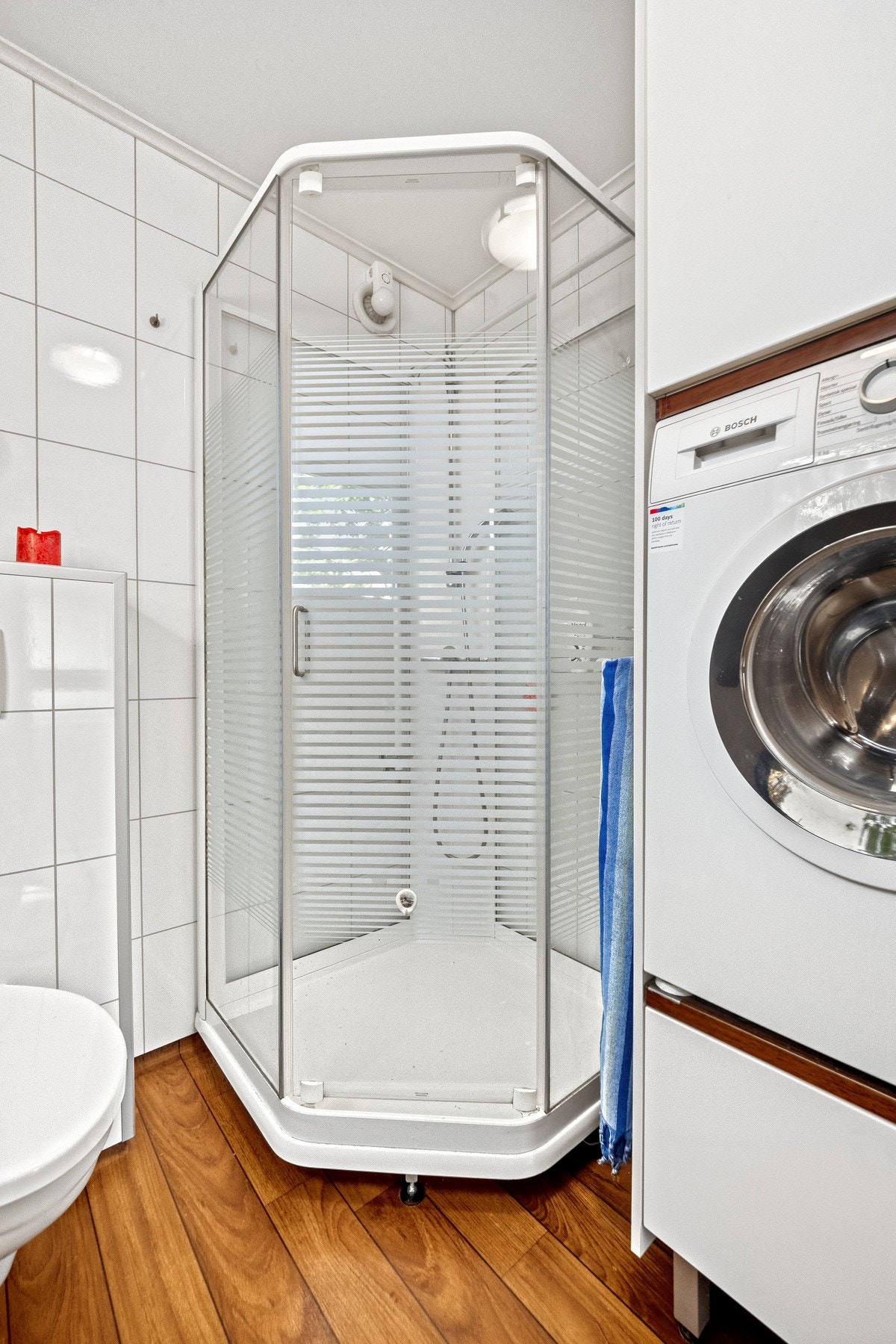 Badet er innredet med dusjkabinett, veggmontert toalett og en pen servantinnredning. Galleribilde
