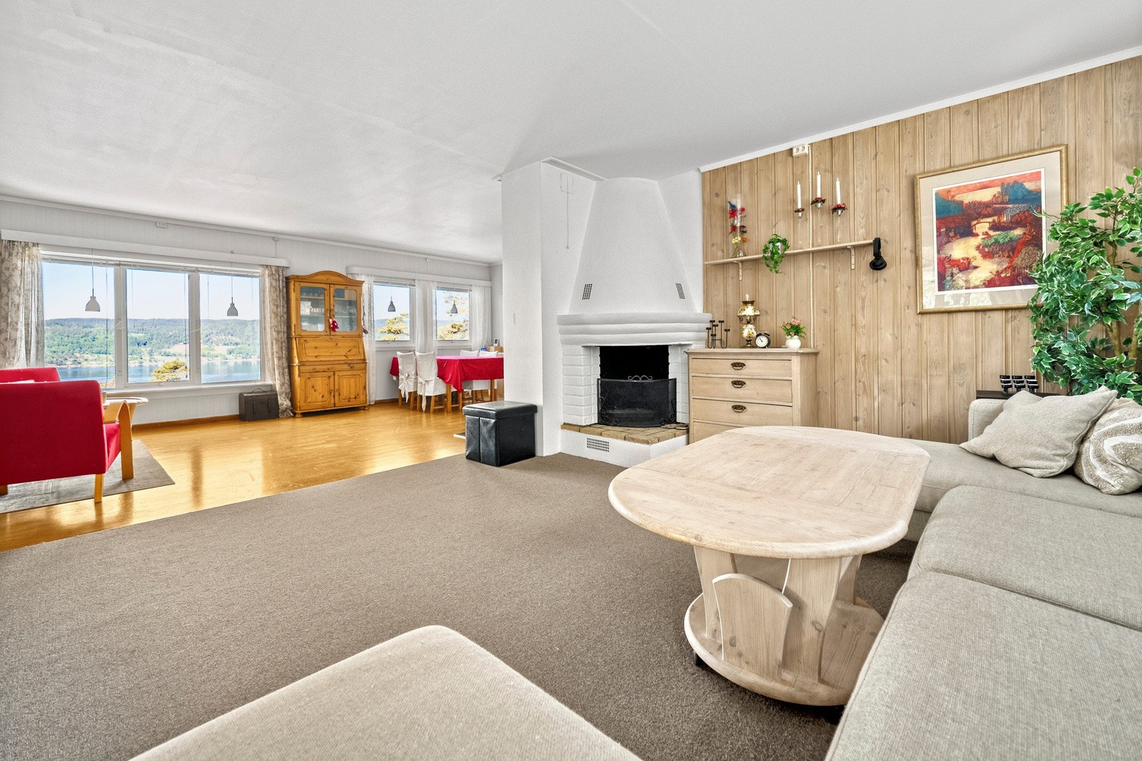 I den innerste delen av stuen er det lagt gulvteppe og murt opp en åpen peis for ekstra hygge. Galleribilde