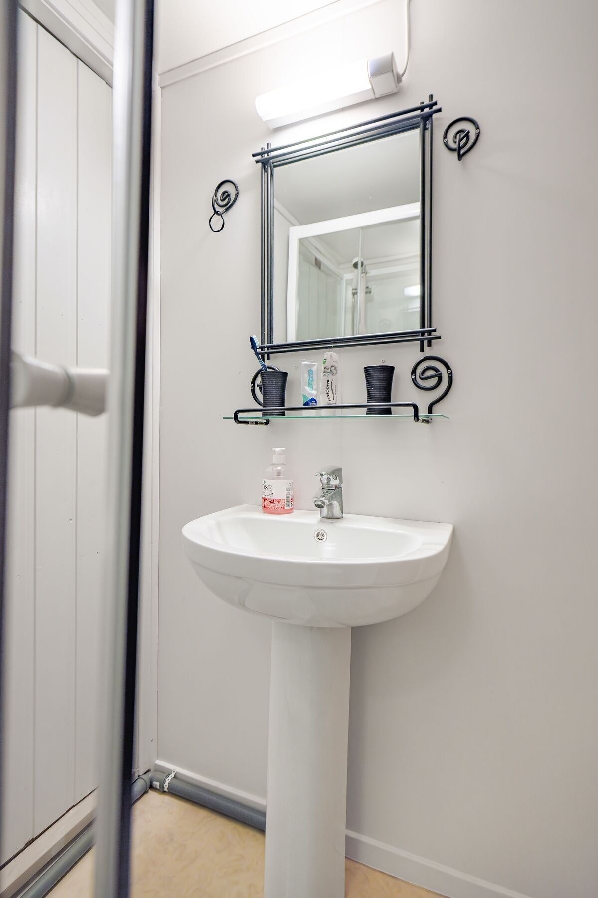 Badet har servant, dusjkabinett og toalett Galleribilde