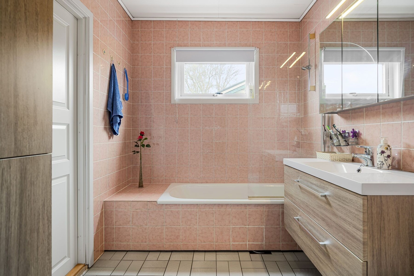 Badet er utstyrt med servant i innredning, badekar og toalett Galleribilde