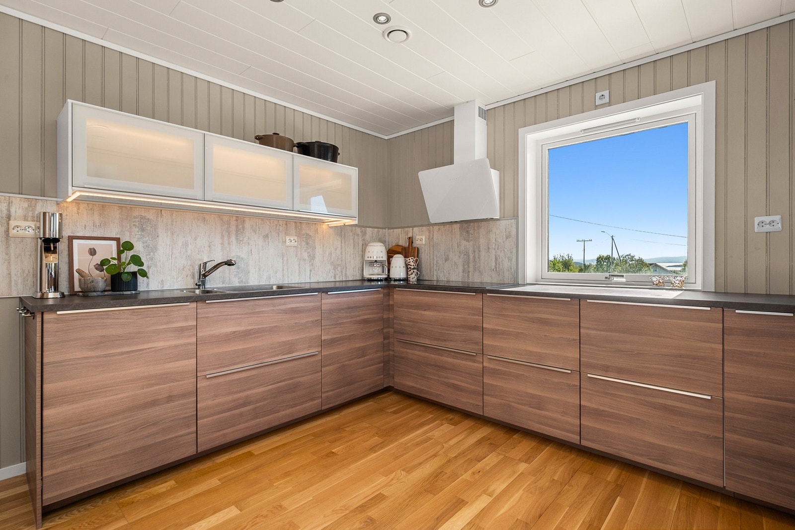 Moderne standard og praktisk utforming gjør dette kjøkkenet til et naturlig midtpunkt i første etasje. Galleribilde