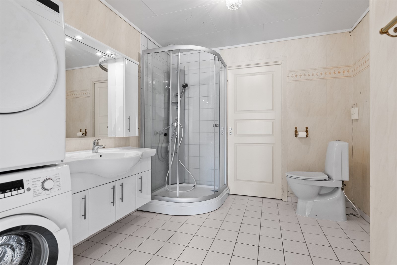 Badet har flislagt gulv med elektriske varmekabler, dusjkabinett og servantinnredning. Galleribilde