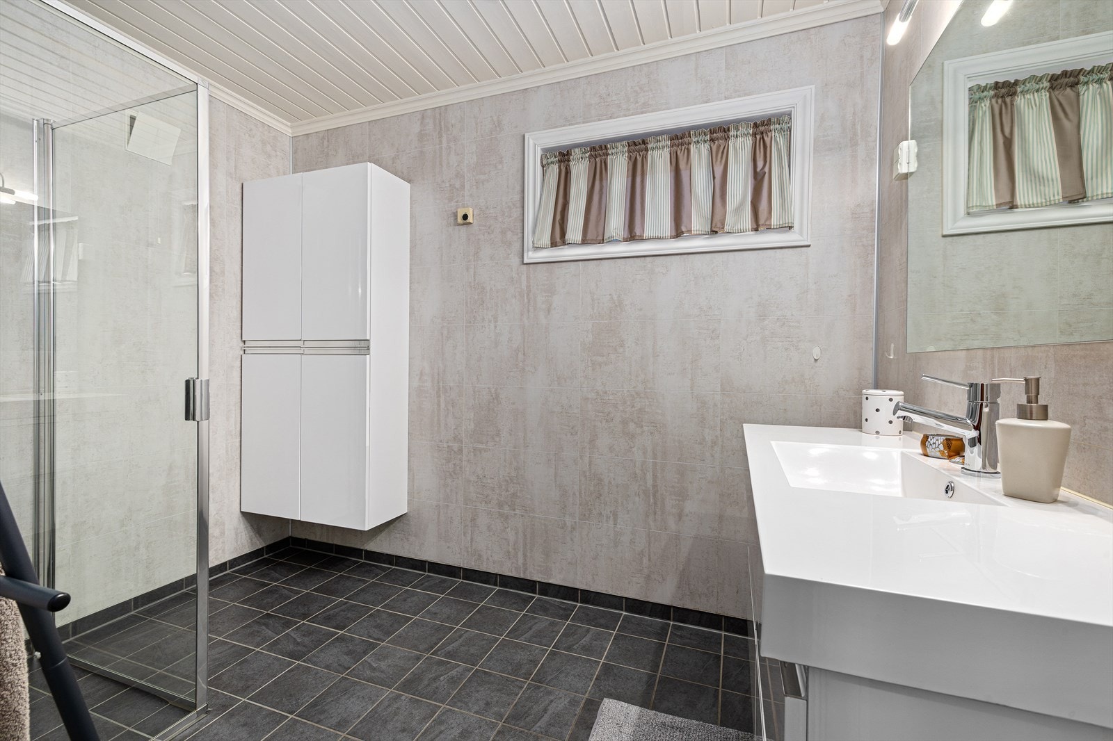 Badet i underetasjen ble oppgradert av fagfolk i 2014 og har baderomsplater på veggene. Galleribilde