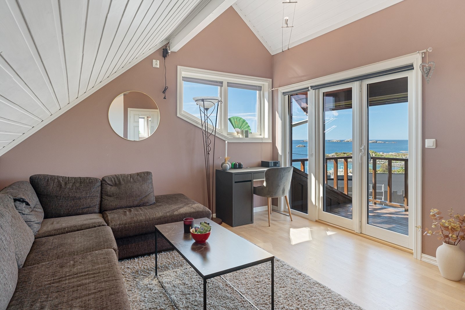 Loftsstue med plass til stor sofagruppe og utgang til overbygget balkong. Galleribilde