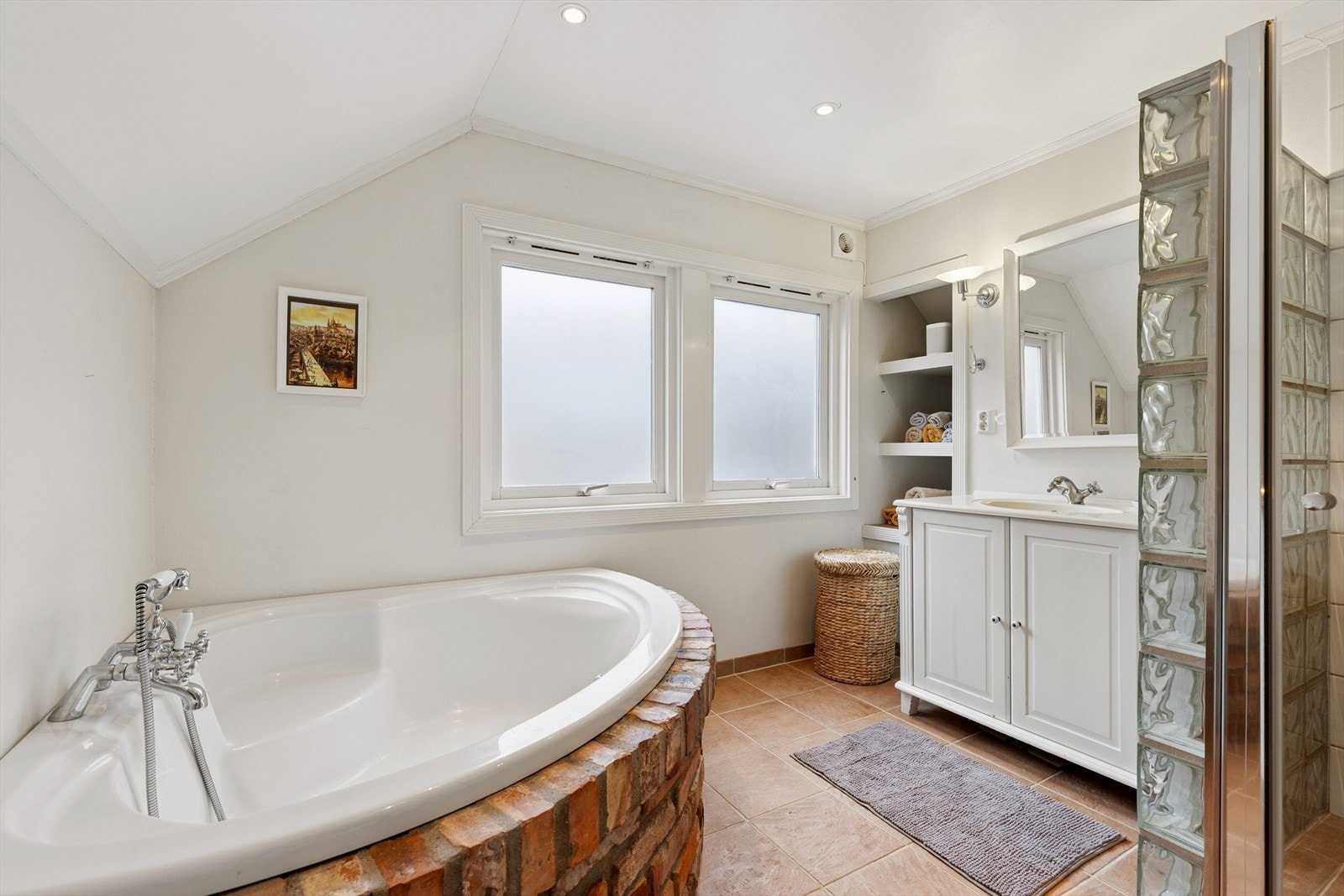 Badet på loftet er romslig og ble pusset opp i 2000. Det har både dusjnisje og et innbygget hjørnebadekar. Galleribilde