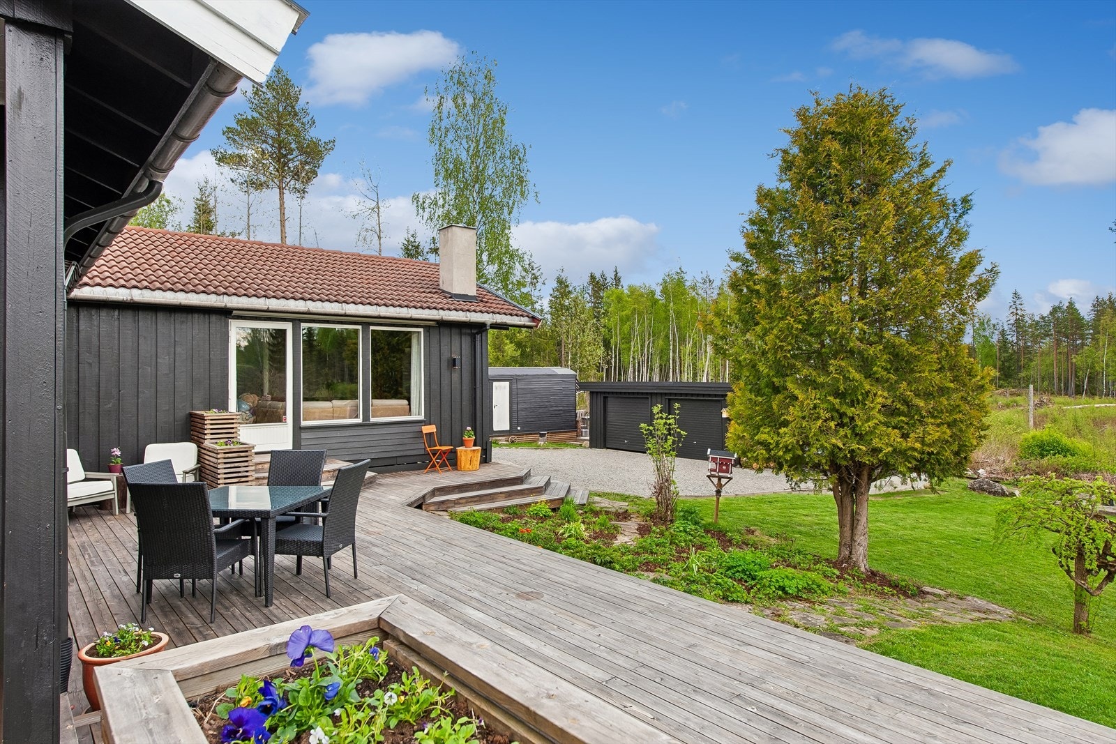 Den åpne terrasseplattingen har trapper ned til hagen, som har usjenert beliggenhet mot skogen.. Galleribilde