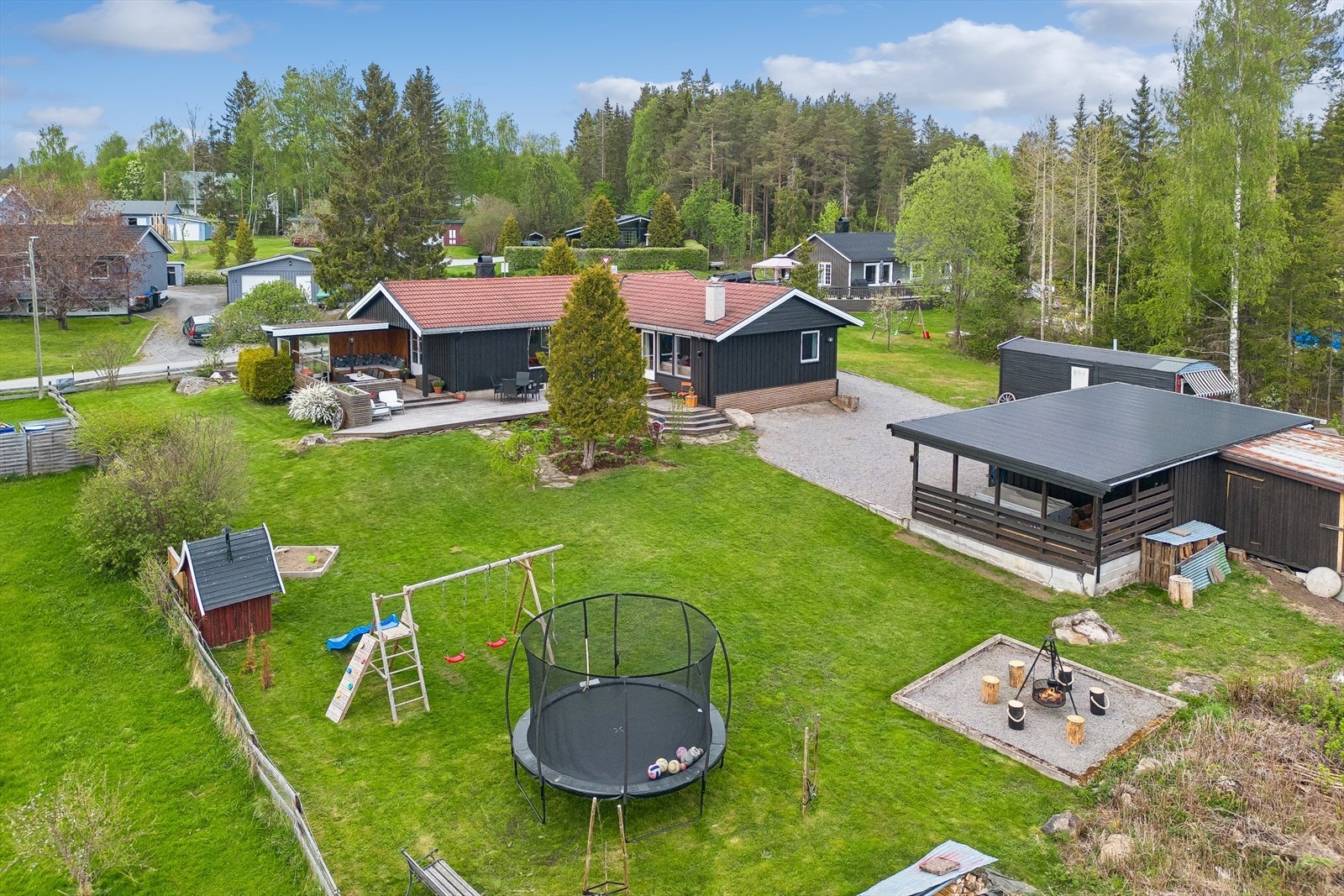 Eiendommen inkluderer et garasjebygg med bod og en tilhørende carport. Det gjøres oppmerksom på at huskestativ og lekestue ikke medfølger. Galleribilde