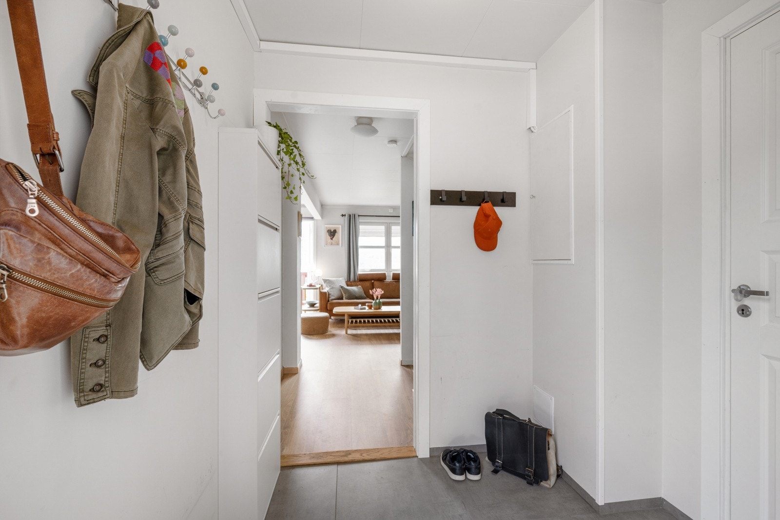 Du ønskes velkommen inn til boligens hovedetasje og en lys, flislagt entré. Her er det god plass til å henge fra seg yttertøy og sette fra seg sko. Galleribilde