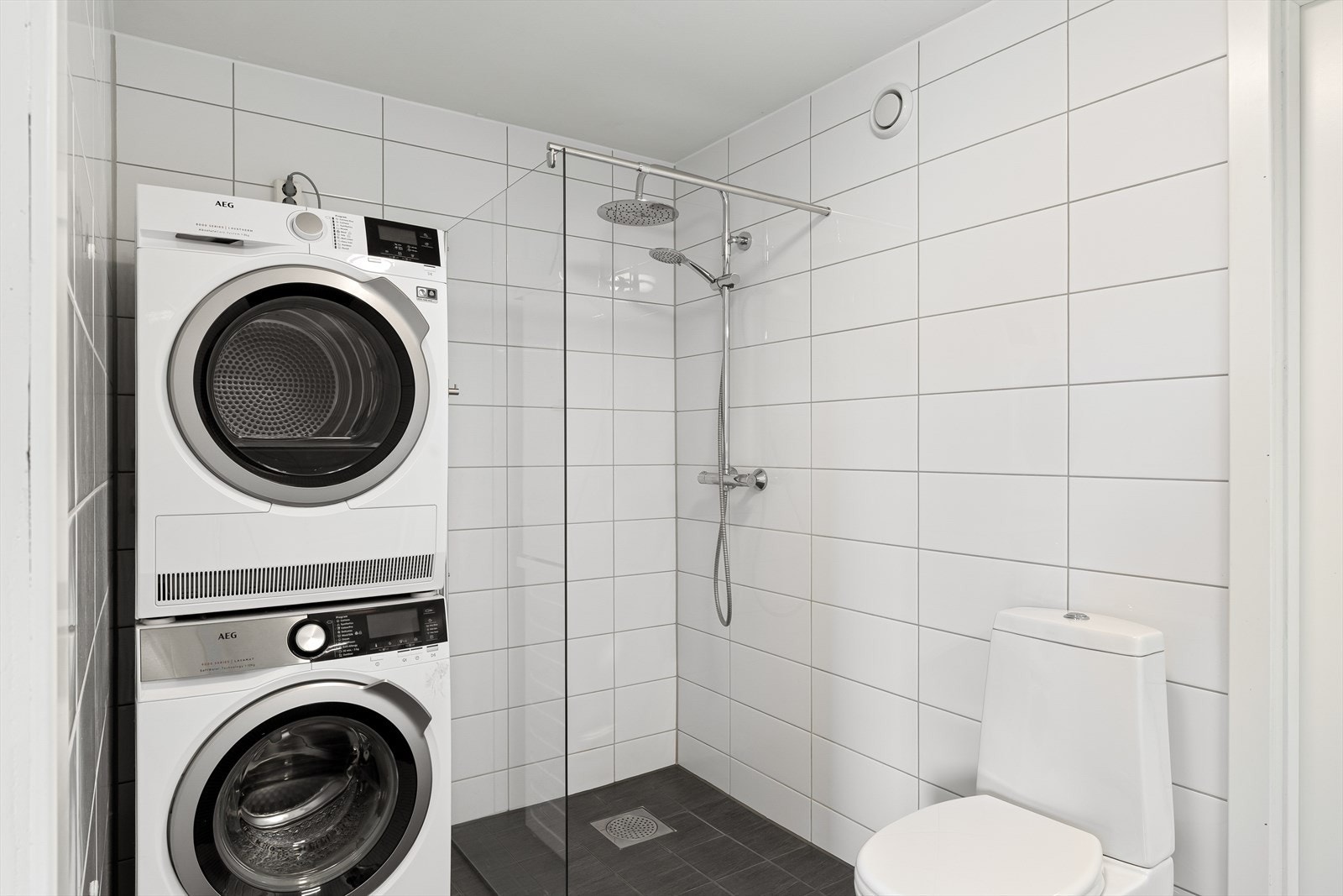 Badet er utstyrt med dusjhjørne med glassvegger og har opplegg for vaskemaskin. Galleribilde