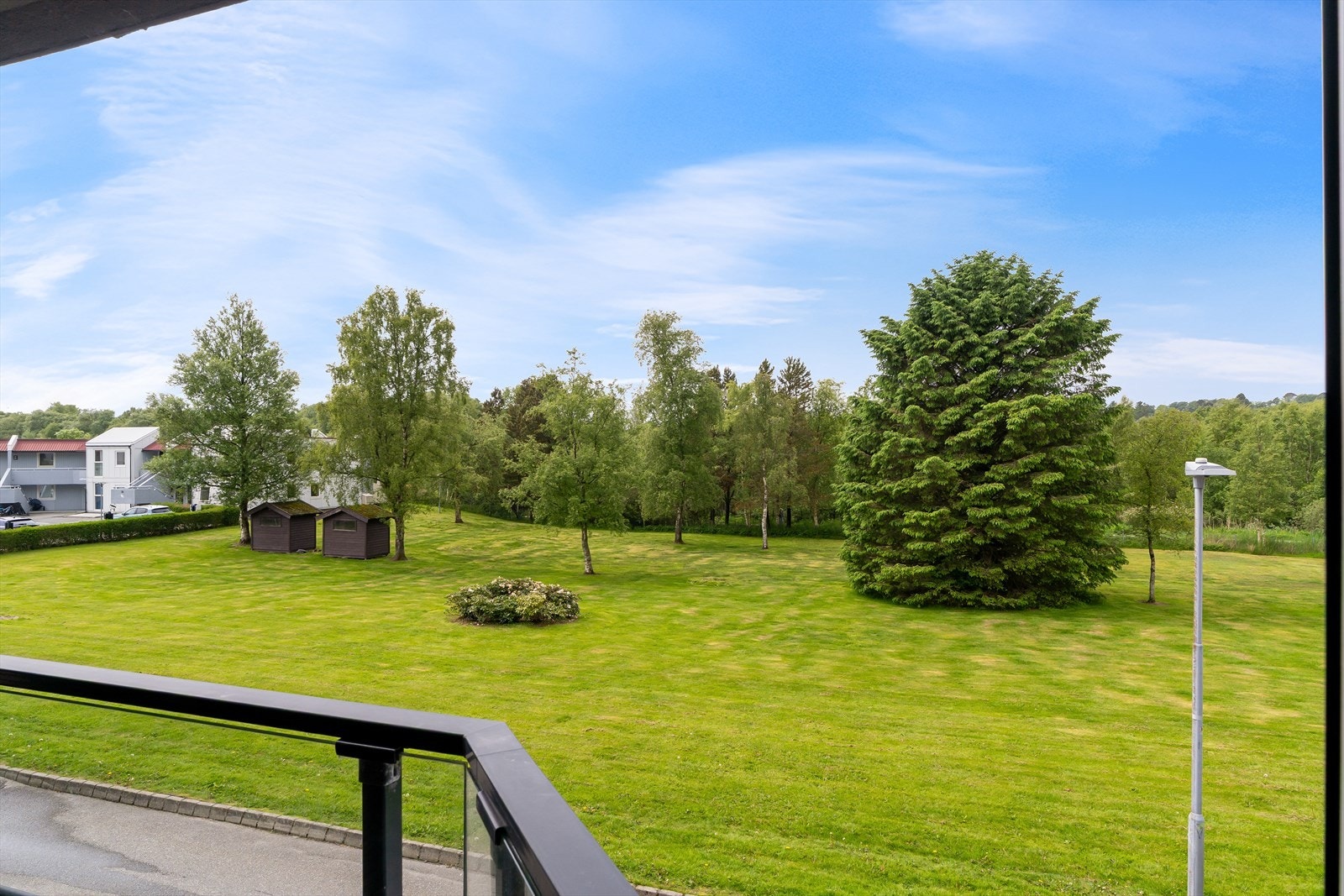 Fra balkongen er det utsikt over store, grønne fellesarealer. Galleribilde