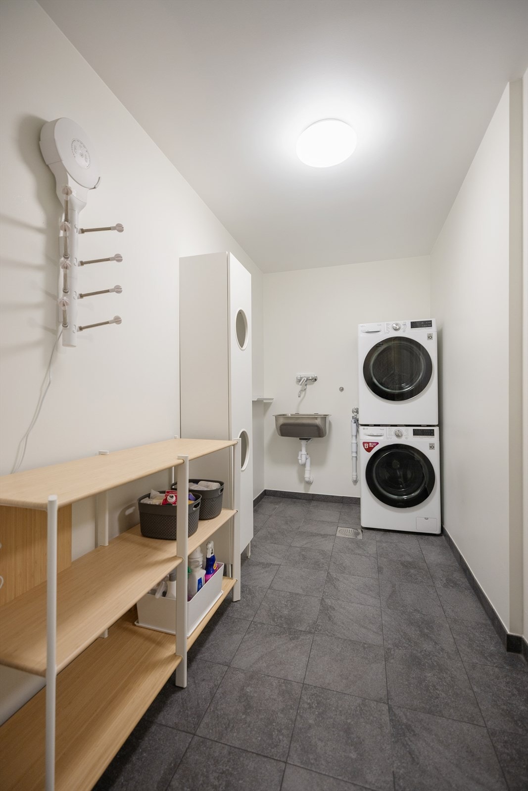 Vaskerommet er funksjonelt innredet med skyllekar, opplegg for vaskemaskin og varmekabler i gulv. Galleribilde