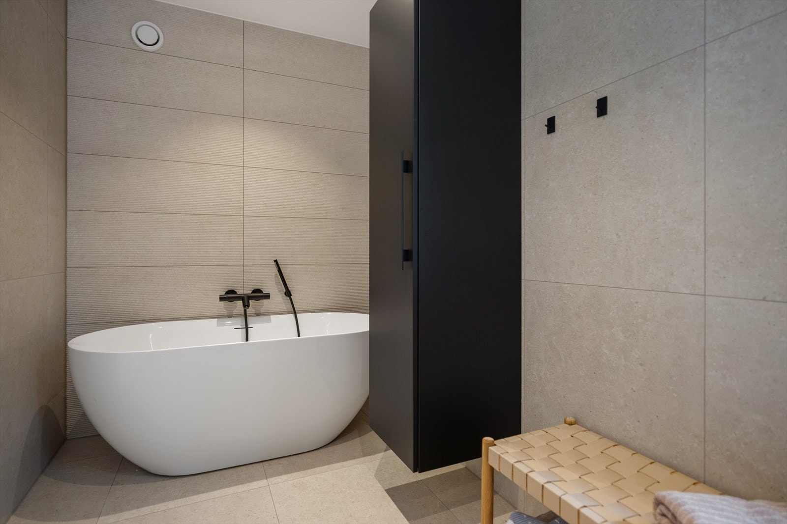 Badet er utstyrt med både dusjnisje med glassdører og et frittstående badekar i helstøpt plast. Galleribilde