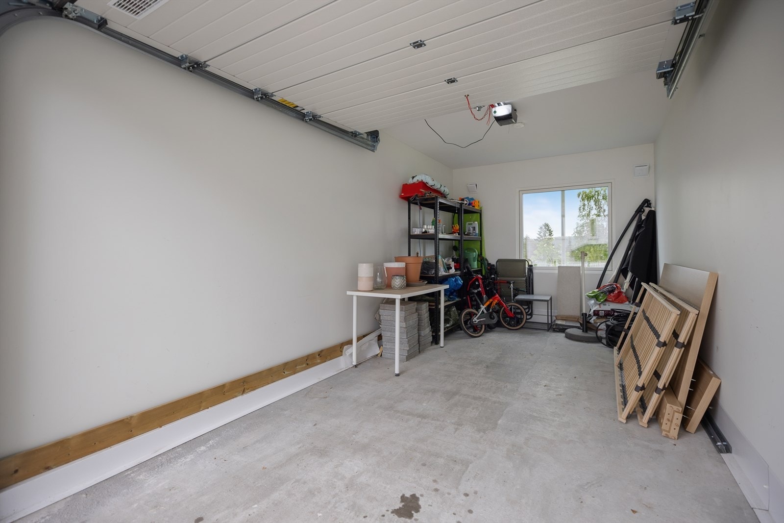 Integrert garasje med elektrisk portåpner. Det er også en egen biloppstillingsplass på tomten. Galleribilde