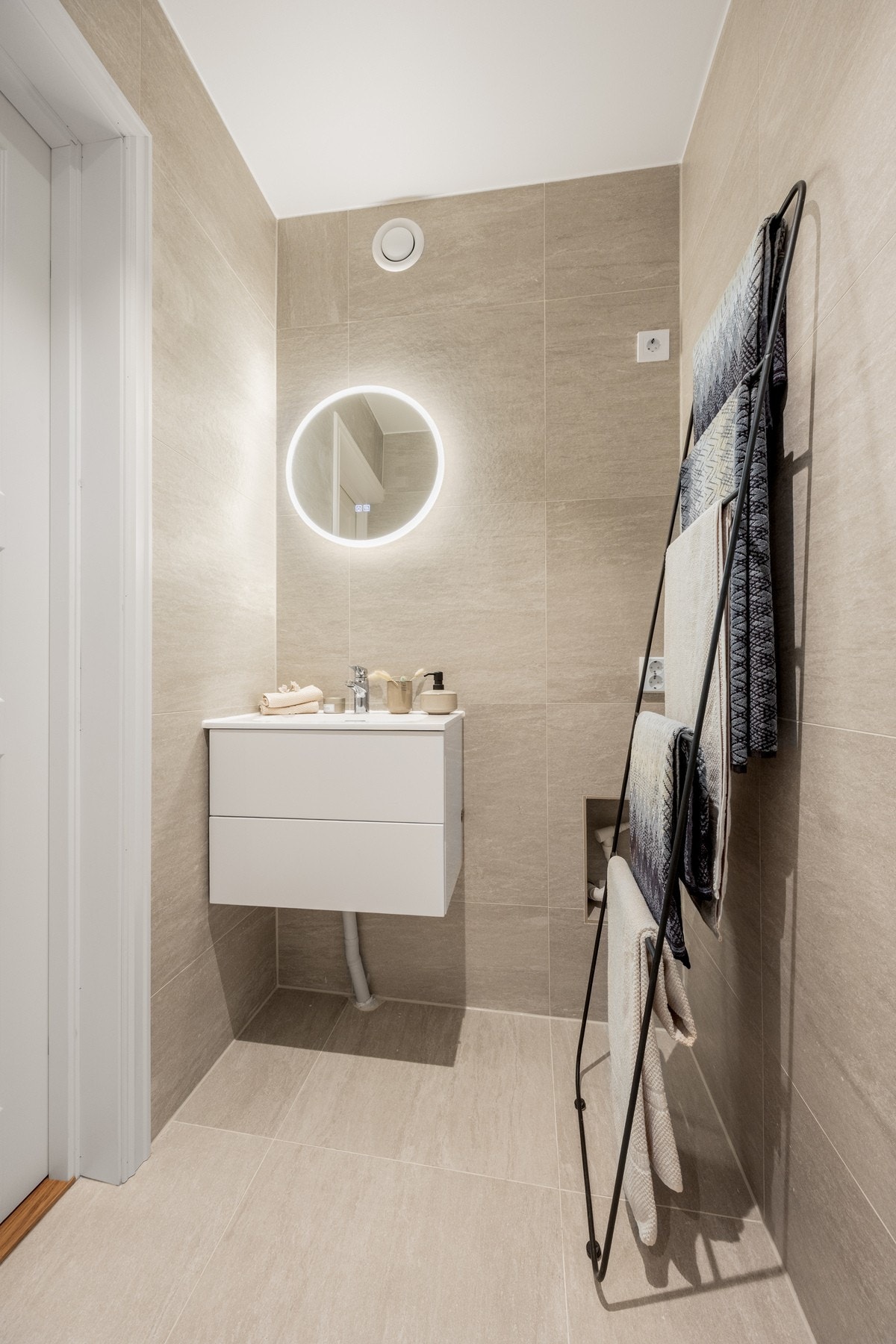 Flotte italienske fliser, downlights og stilrene detaljer gir badet et eksklusivt og harmonisk uttrykk. Opplegg for vaskemaskin og tørketrommel. Galleribilde