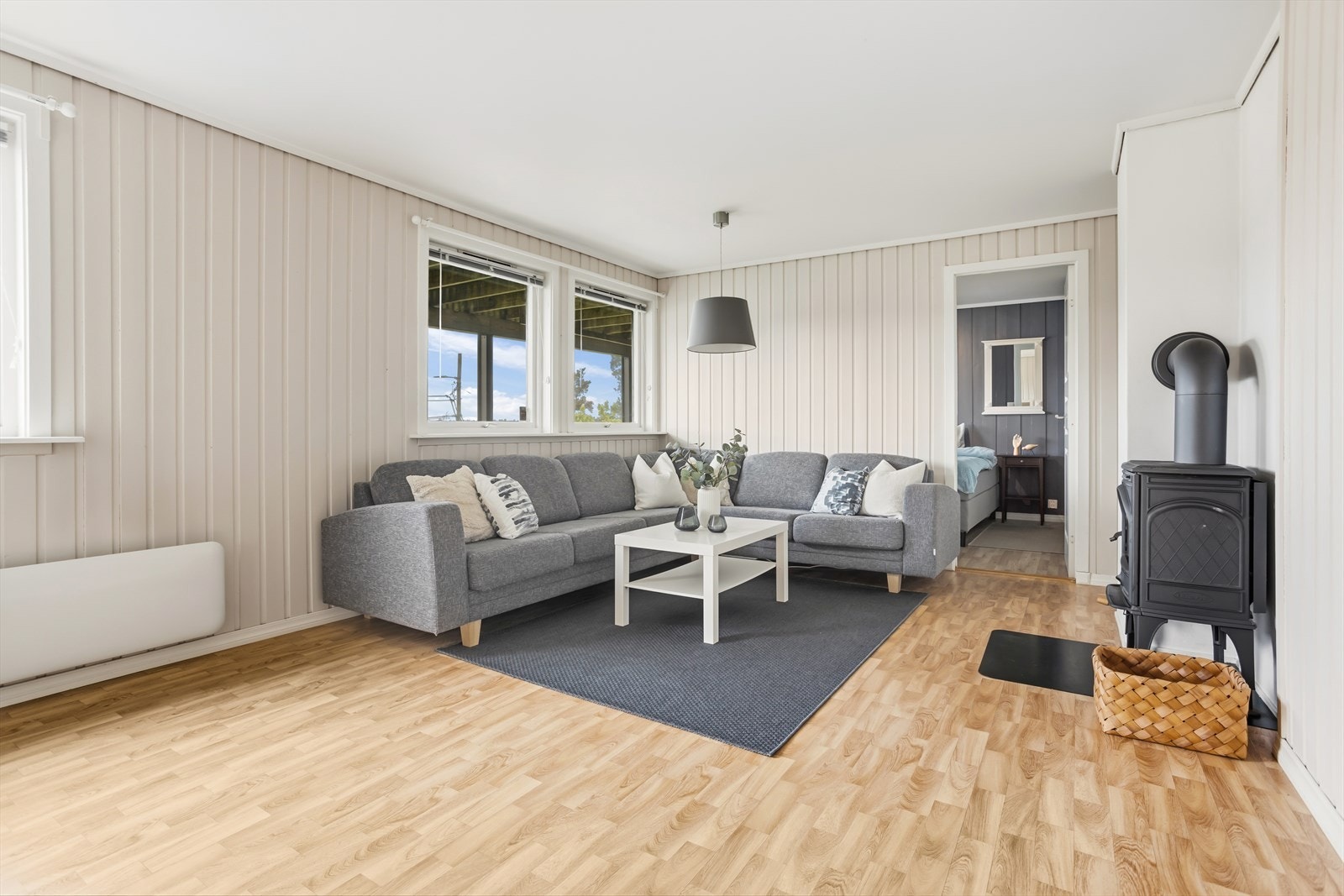 Stuen i sokkelleiligheten har fint gulv og plass til både sittegruppe og spisebord. Galleribilde