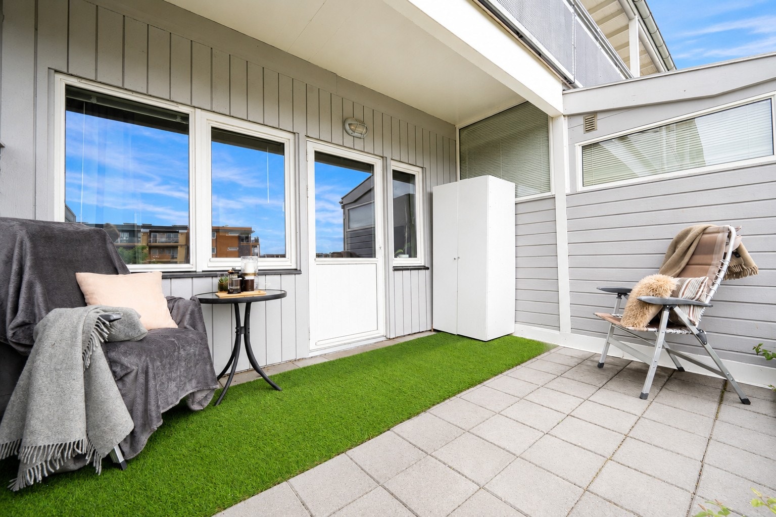 Stein- og kunstgressbelagt terrasse med god plass til utemøbelement. Galleribilde