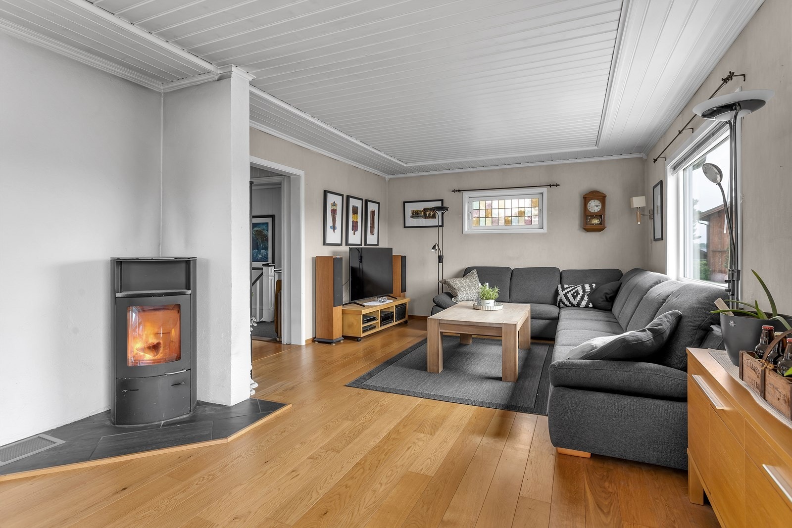 En effektiv vedovn ved mursteinspipen sørger for varme og hygge i stuen. Galleribilde