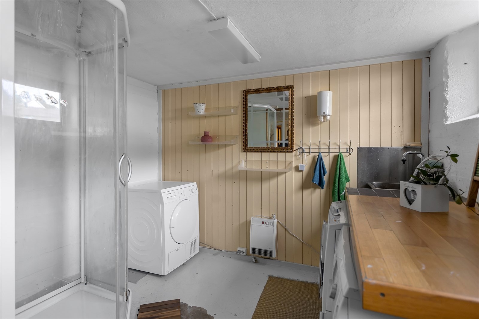 Praktisk vaskerom i kjelleren, utstyrt med dusjkabinett, vaskekum og opplegg for vaskemaskin. Galleribilde