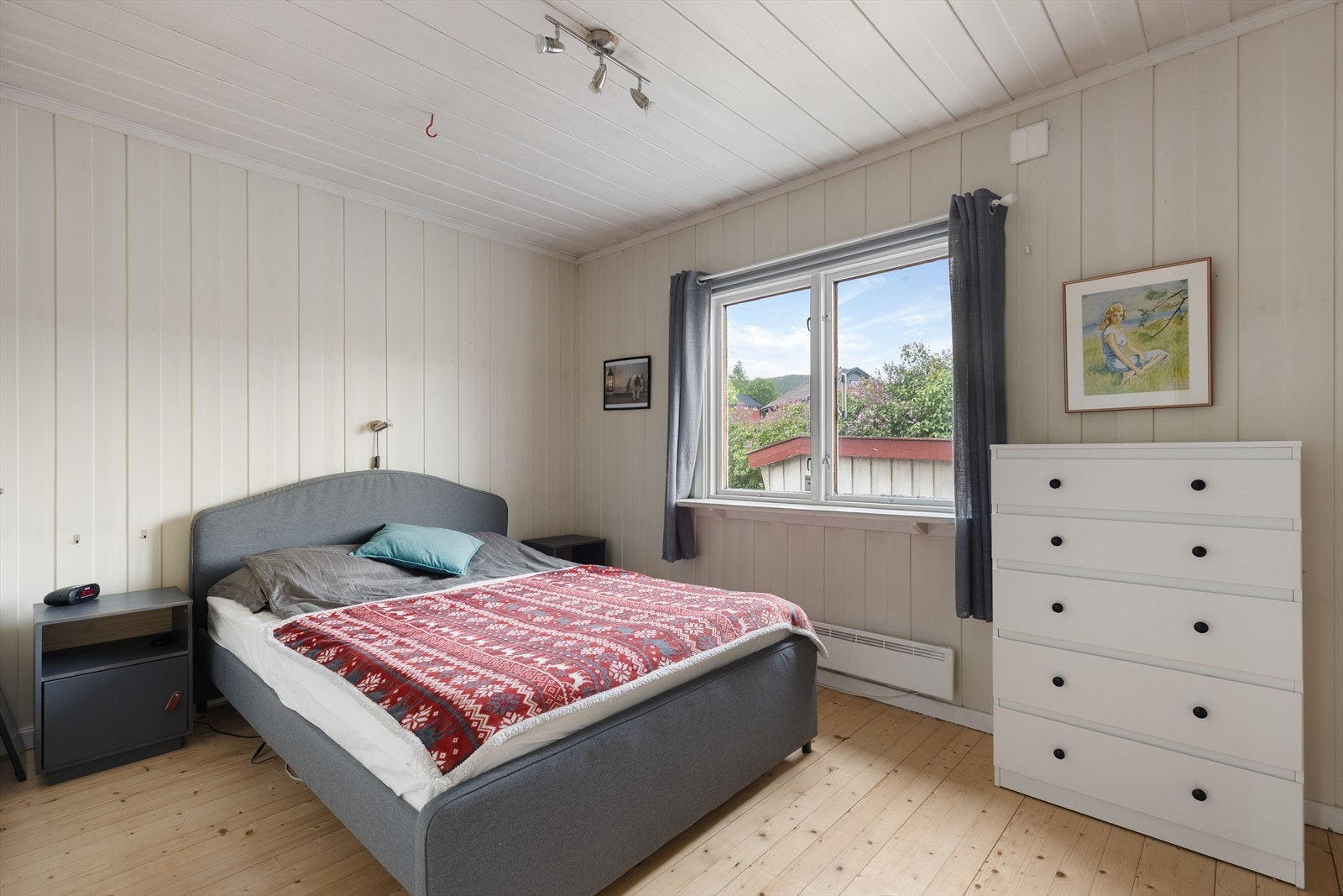 Soverom i hovedetasjen med slipt og lakkert tregulv og malt panel. Galleribilde
