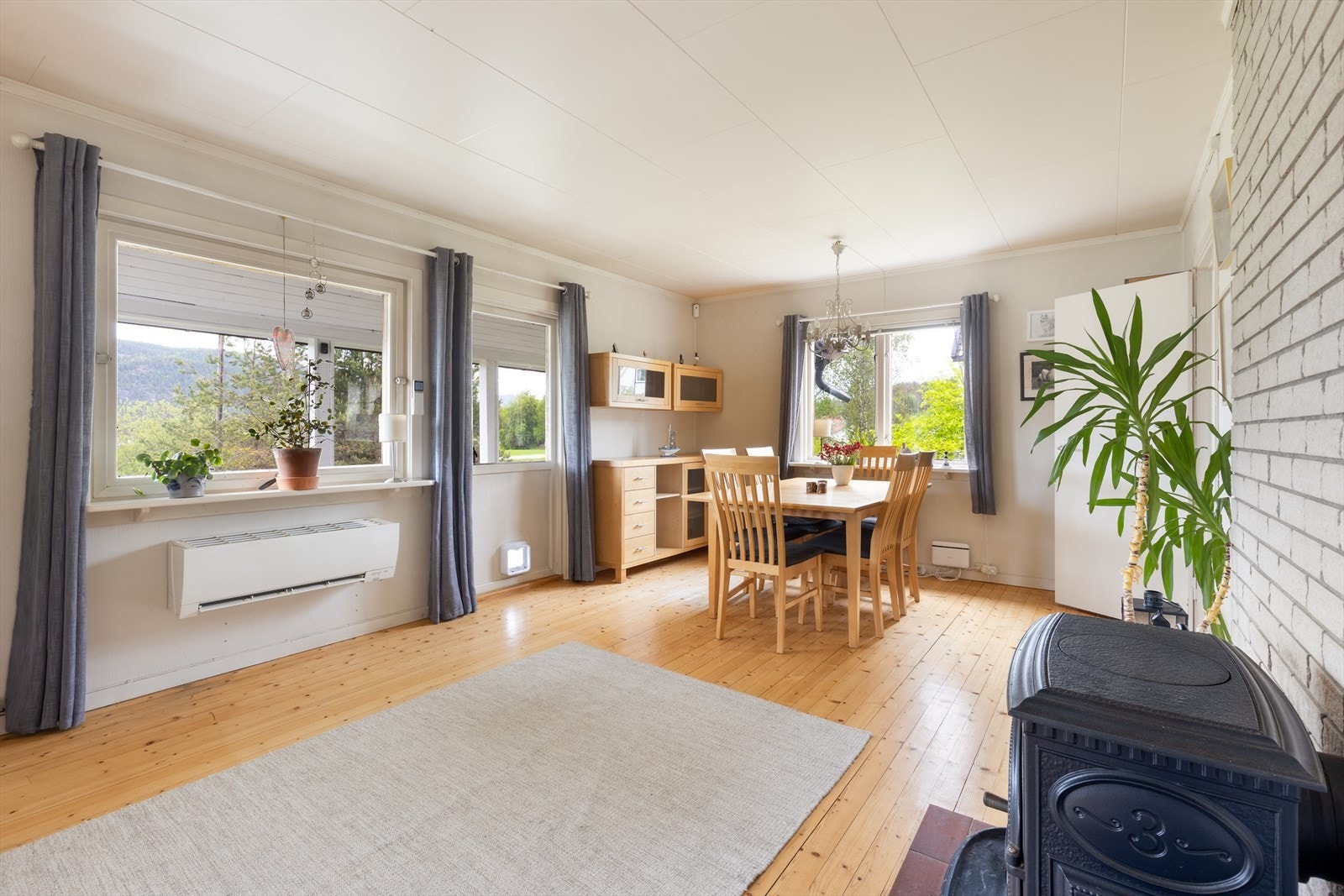 Stuen har plass til både sofagruppe og spisebord. Gulvet er et originalt tregulv som ble slipt og lakkert i 2020. Galleribilde