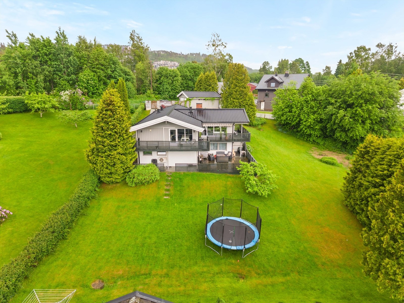 Luftfoto viser boligen med stor hage og gode solforhold. Eiendommen har en attraktiv og familievennlig tomt. Galleribilde