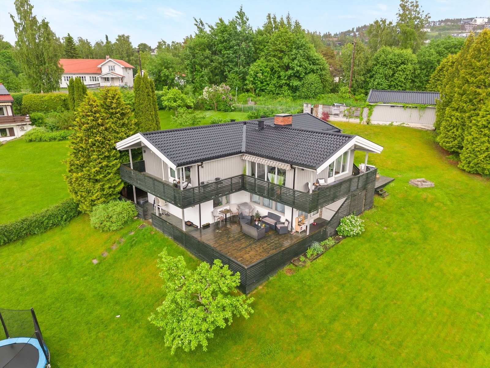 Eiendommen ligger på en romslig og grønn tomt med fine utearealer. Her får man god plass rundt boligen og en skjermet beliggenhet. Galleribilde