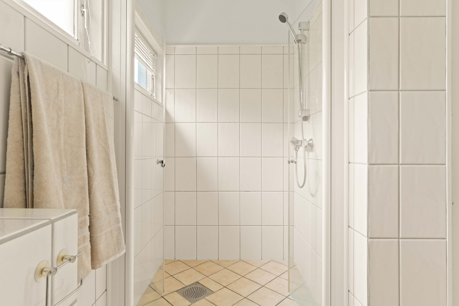 Badet har lyse fliser, dusj og badekar. Et funksjonelt våtrom med god størrelse og tidløst preg. Galleribilde