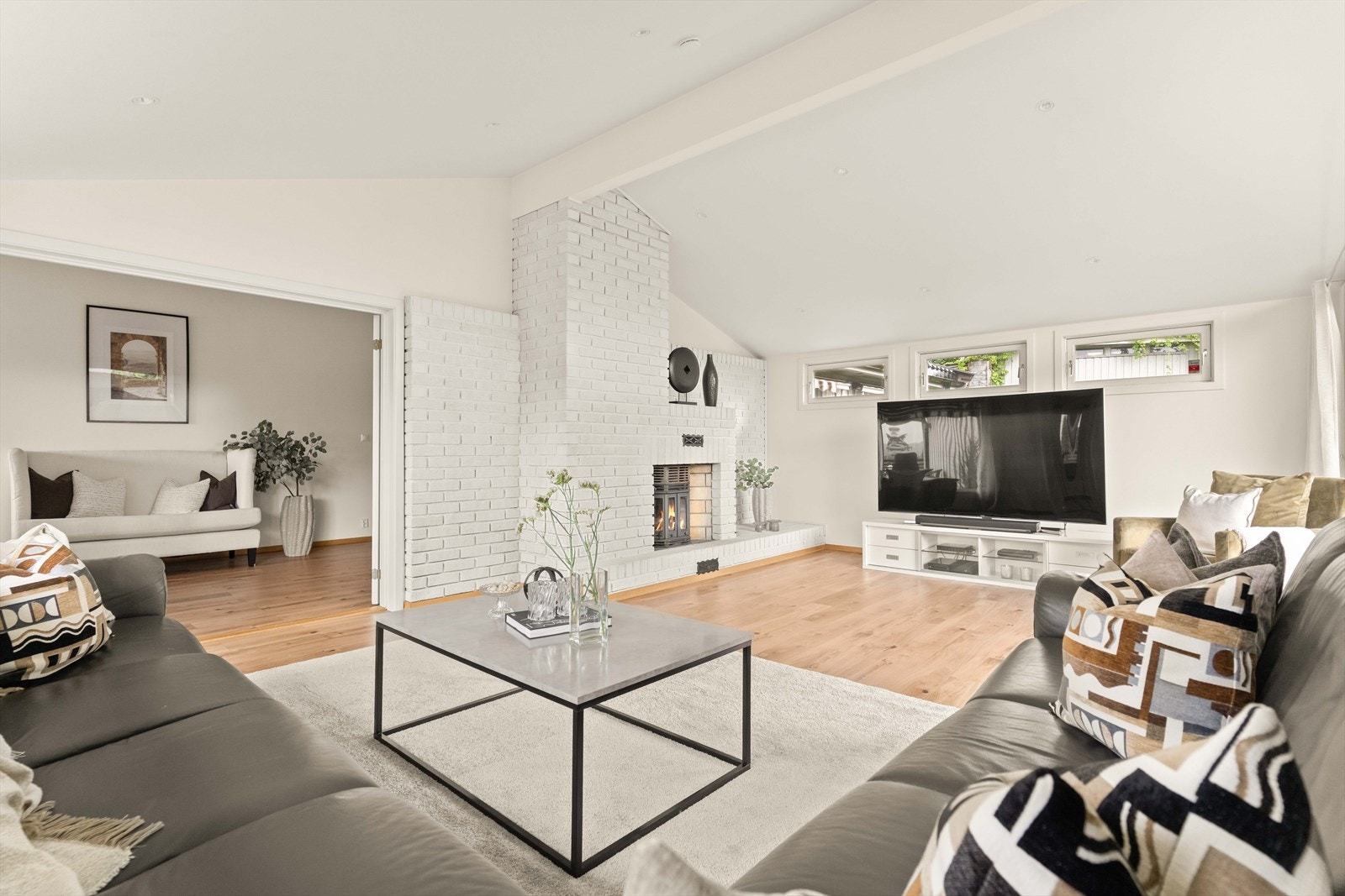En romslig og sosial stue med fin plass til familie og venner. De lyse overflatene gir et moderne og tidløst uttrykk. Galleribilde