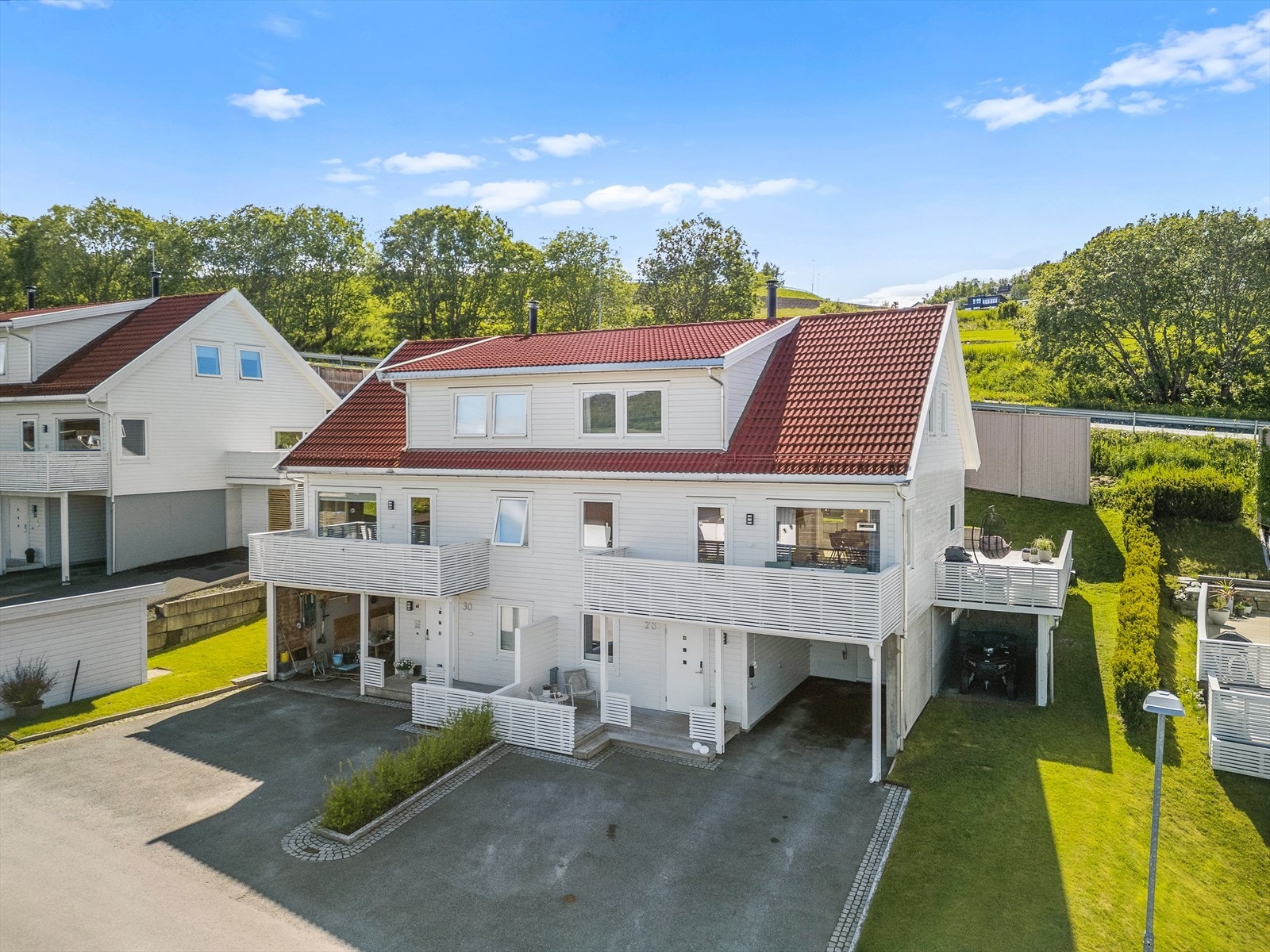 Asfaltert gårdsplass og carport med elbillader. Galleribilde