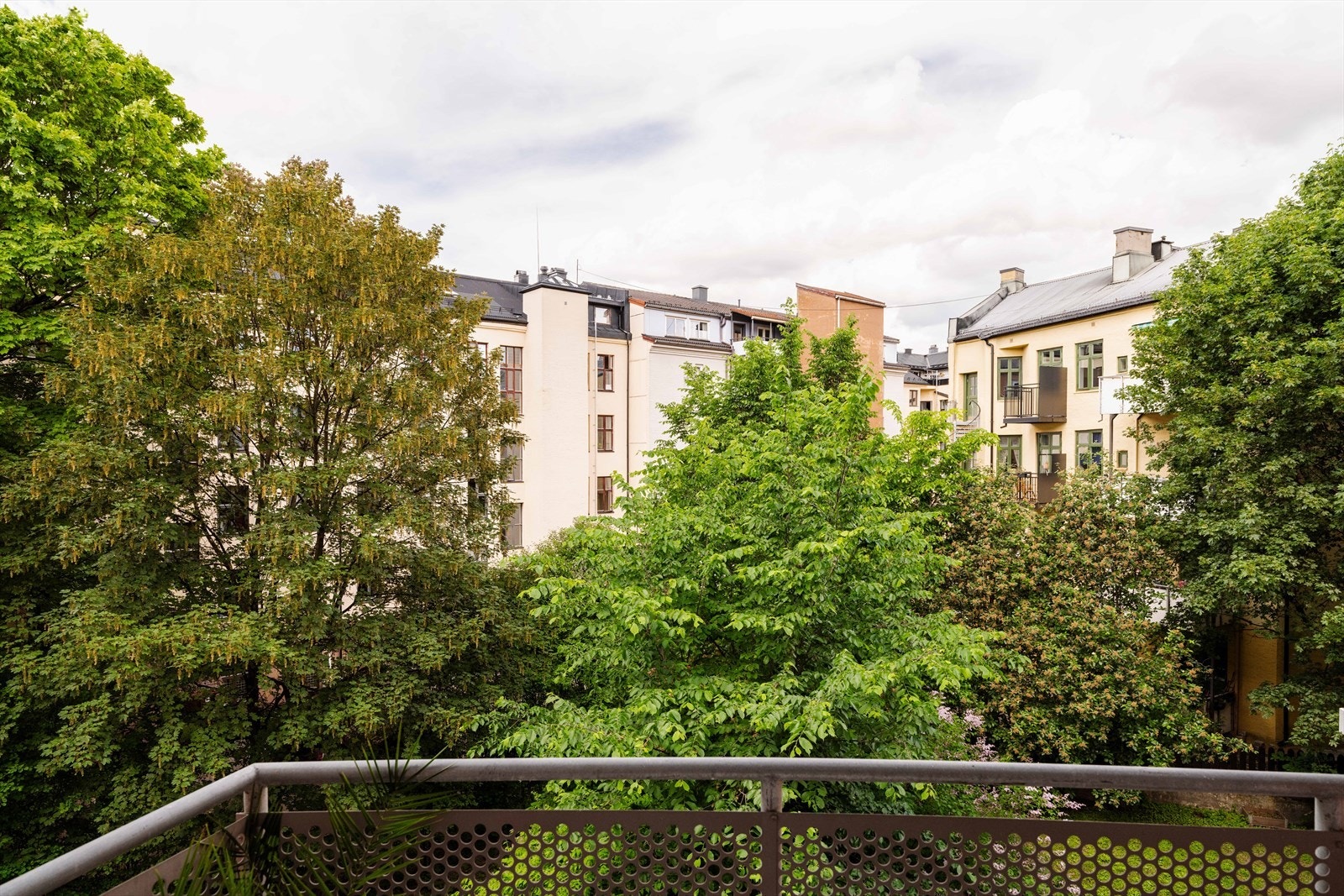 Fra balkongen ser du ut over det rolige og frodige gårdsrommet. Galleribilde