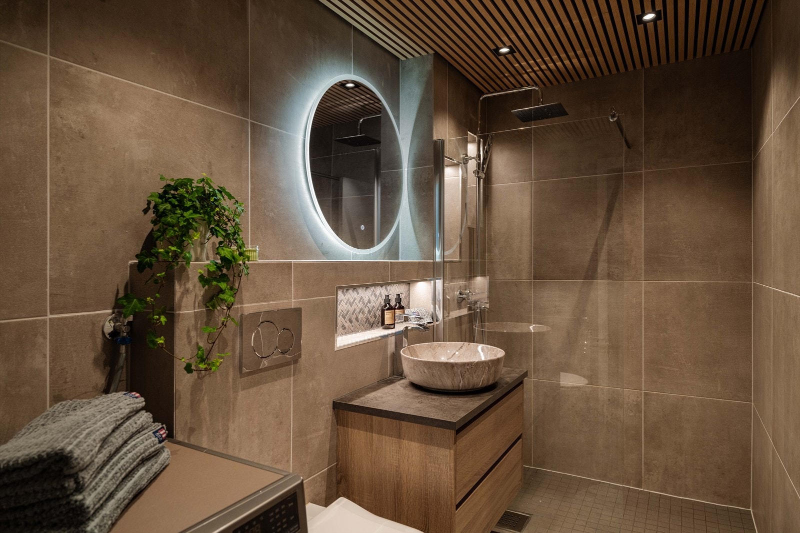 Badet ble pusset opp i 2023 med fliser og varmekabler i gulvet. I taket er det lekre spiler med downlights. Galleribilde