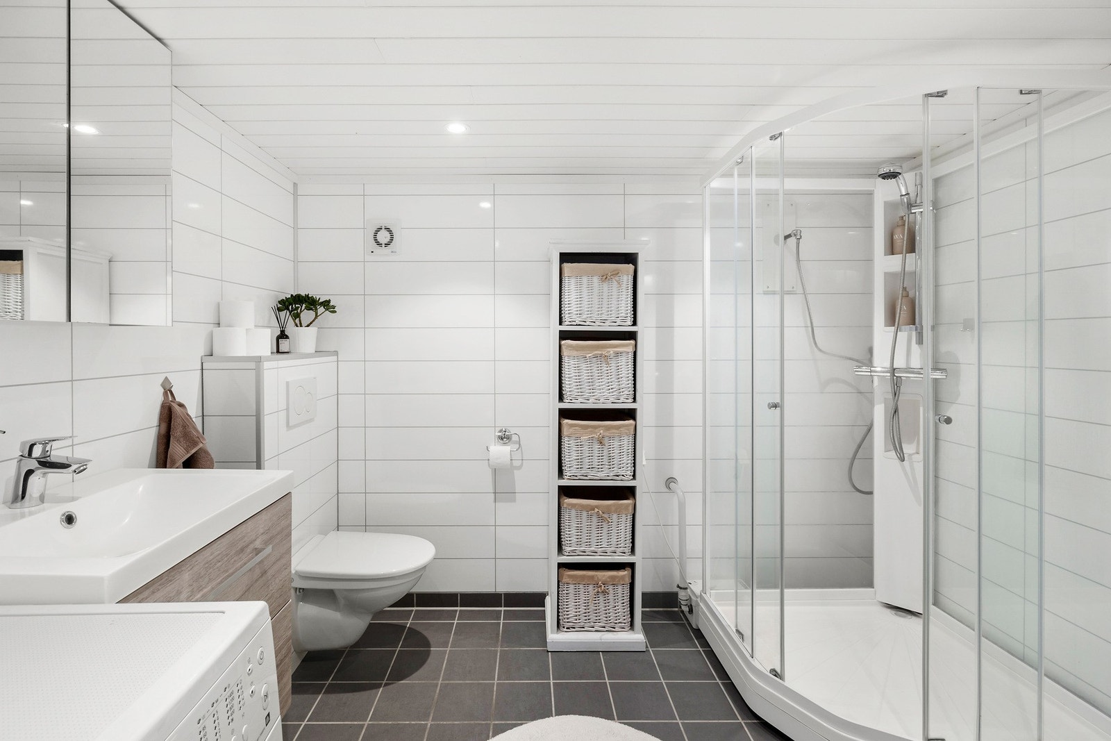 Badet i kjelleren er på 6 kvm. Grunnet manglende sluk, kvalifiserer ikke rommet som våtrom. Dusjkabinettet er tilkoblet en pumpe som pumper vann opp til avløpsrør lengre opp på veggen. Galleribilde