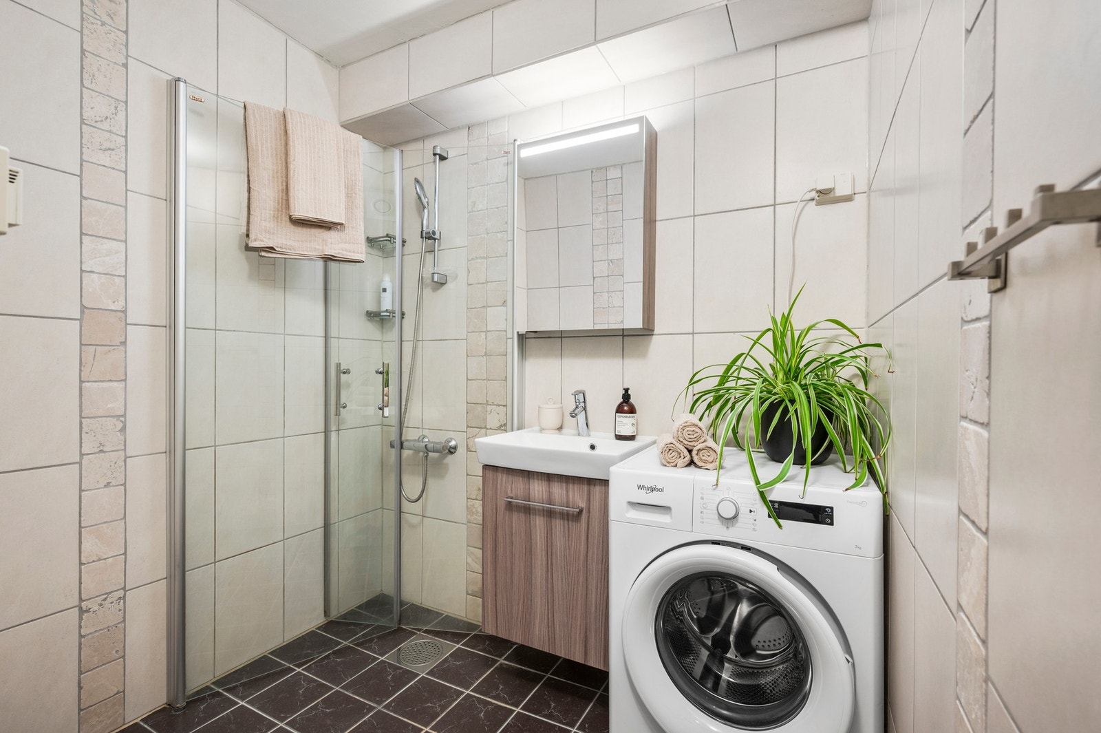 Badet er på 3,3 m² innredet med vegghengt servantinnredning og dusjhjørne. Galleribilde
