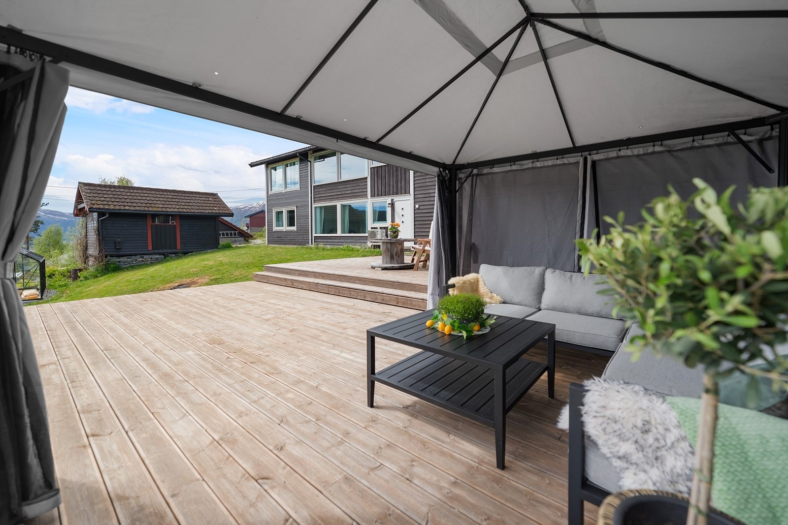 Terrassen har romslig område med tredekke og enkel tilgang til hage. Galleribilde