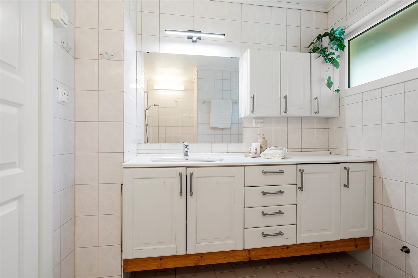 Bad til hoveddelen med toalett, dusjnisje og servant med underskap. Galleribilde